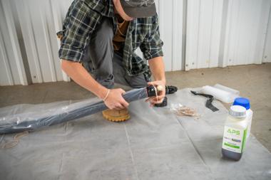 Technician preparing a CIPP packer with APS Versa-Patch resin during a trenchless pipe repair installation.