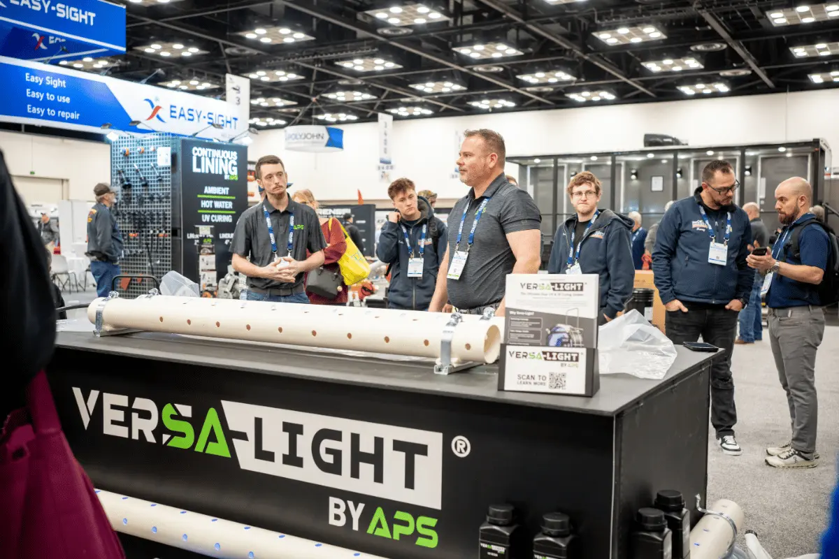 APS team demonstrating the Versa-Light UV curing system at WWETT show showcasing UV pipe rehabilitation equipment and CIPP solutions.