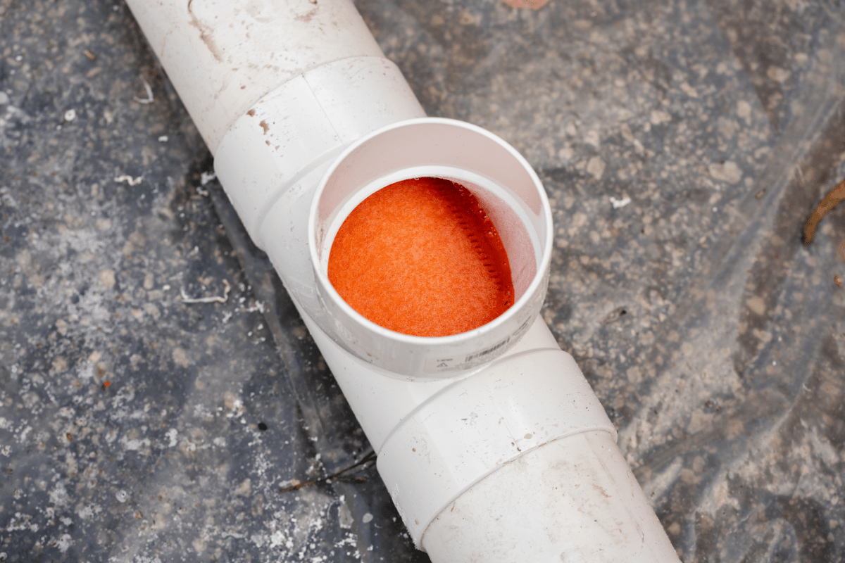 Installed Houseliner inside a PVC tee, demonstrating a cured-in-place pipe (CIPP) point repair application.