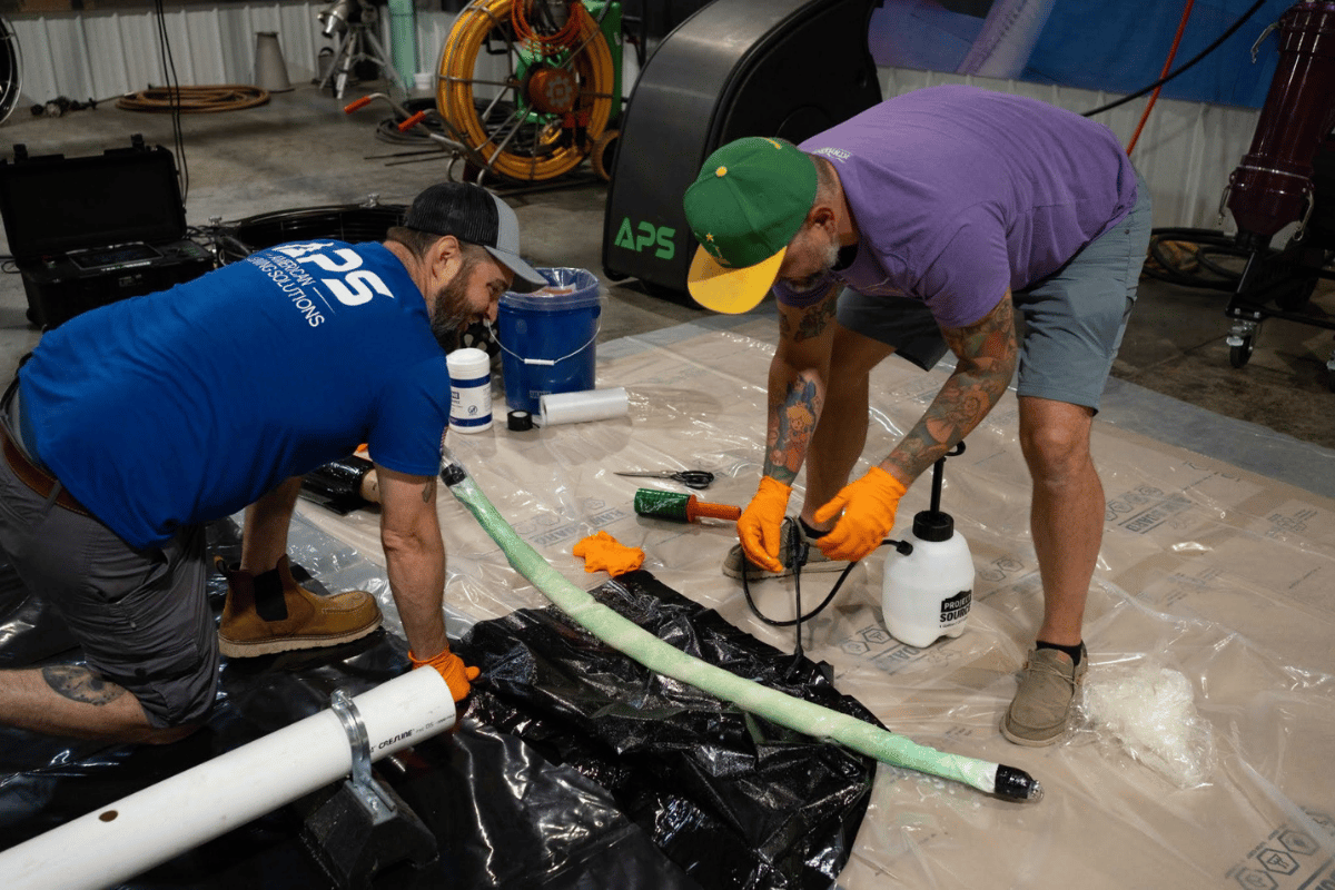 APSTA trainee preparing Versa-Light with an APS trainer during hands-on trenchless pipe lining training.