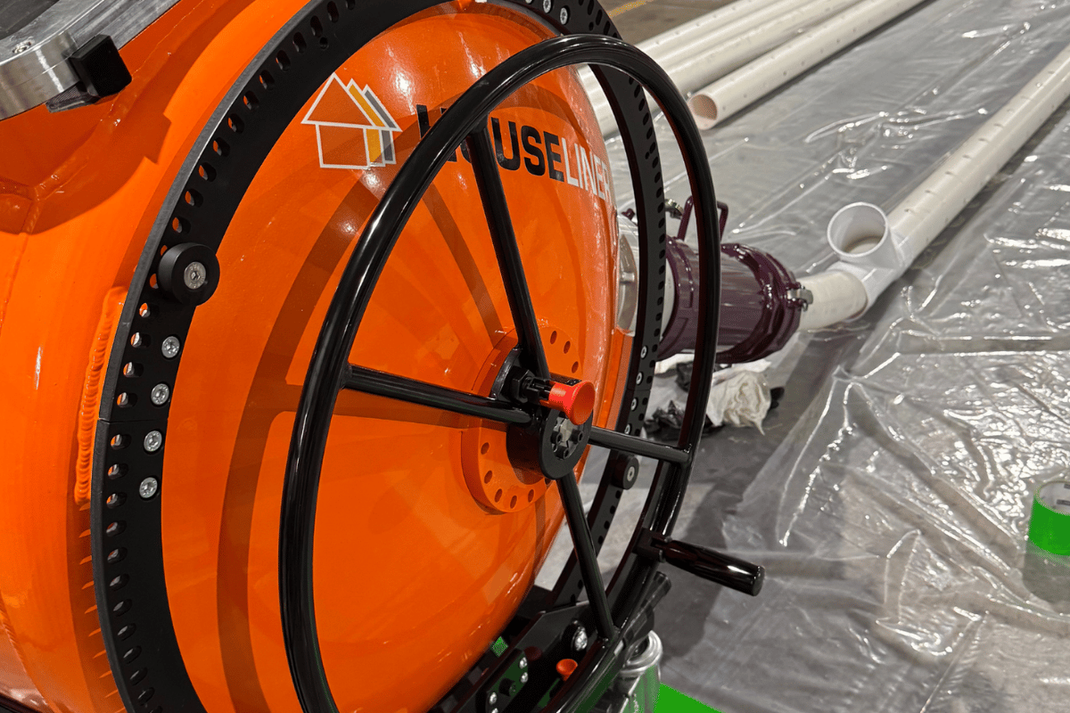 American Pipelining Solutions Houseliner inversion drum connected to a cured-in-place pipe (CIPP) liner during trenchless sewer rehabilitation setup.